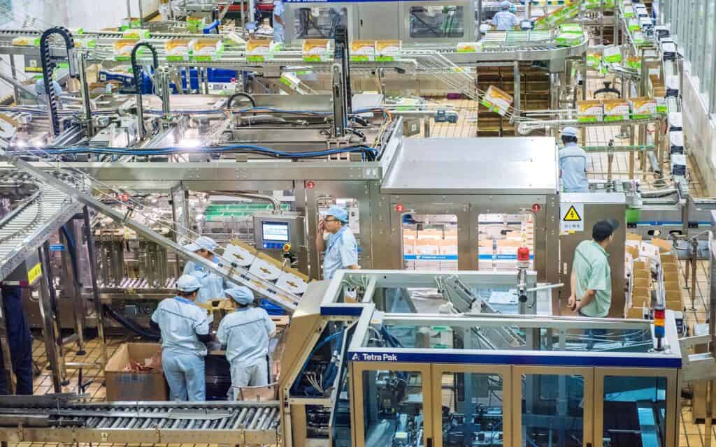 Food processing facility with various workers around machines